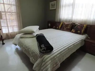 a bedroom with a bed with a blanket on it at Unique Kruger Hide & Spa in Marloth Park