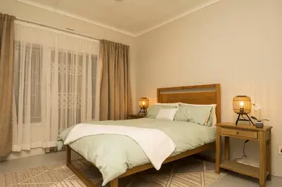 a bedroom with a bed and two lamps on tables at Eagles View in Hartbeespoort