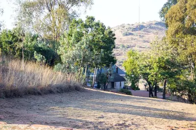 a dirt road in front of a house with a hill at Eagles View in Hartbeespoort