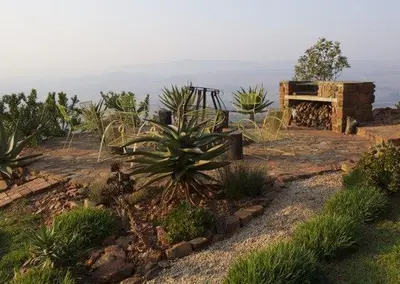 a garden with cacti and plants on a hill at Eagles View in Hartbeespoort