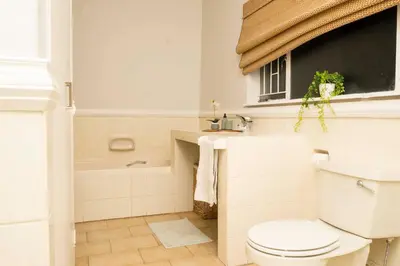 a bathroom with a toilet and a tub and a window at Eagles View in Hartbeespoort