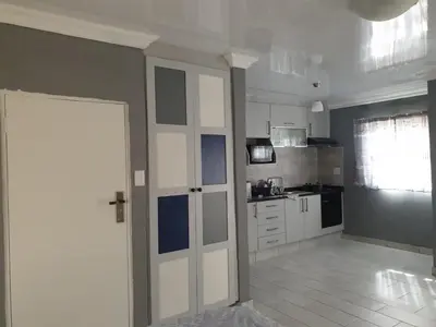 a kitchen with a door leading into a kitchen with a counter at Cuse guest house in Polokwane