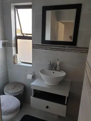 a bathroom with a sink and a toilet and a mirror at Cuse guest house in Polokwane