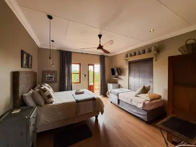 a bedroom with two beds and a ceiling fan at The Urn Guesthouse in Middelburg
