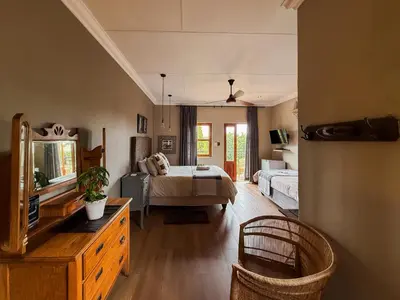 a bedroom with a bed and a dresser in a room at The Urn Guesthouse in Middelburg