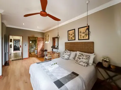 a bedroom with a bed and a ceiling fan at The Urn Guesthouse in Middelburg