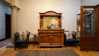 a room with a wooden dresser and two chairs at The Urn Guesthouse in Middelburg