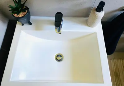 a white sink with a faucet and a plant at The Minimalist Hideout in Midrand