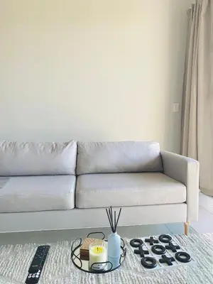 a living room with a couch and a table at The Minimalist Hideout in Midrand