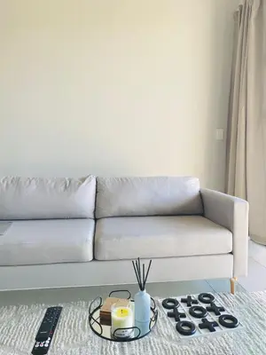 a living room with a couch and a table at The Minimalist Hideout in Erand