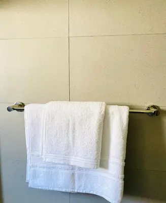 two towels hanging on a towel rack in a bathroom at The Minimalist Hideout in Erand