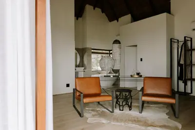 a dining room with two chairs and a table at Rhino Plains in Welgevonden Game Reserve