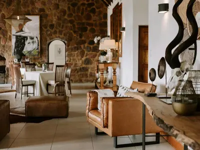 a living room with leather chairs and a table at Rhino Plains in Welgevonden Game Reserve