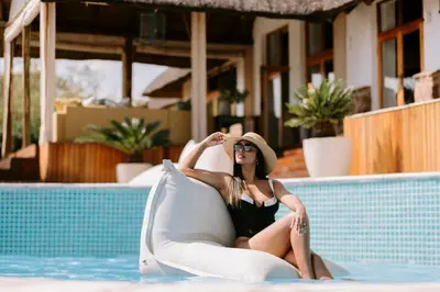 a woman sitting on a raft in a swimming pool at Rhino Plains in Welgevonden Game Reserve