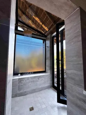 a room with a large window with a large tv at Rhino Plains in Welgevonden Game Reserve