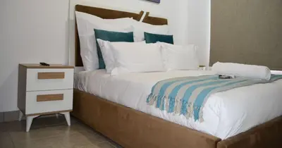 a bedroom with a large bed with a night stand at Moon Octave in Midrand