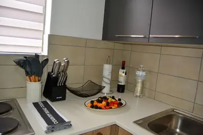 a kitchen counter with a bowl of fruit and a bottle of wine at Moon Octave in Midrand
