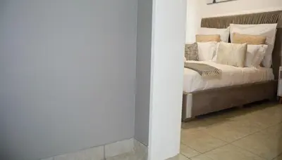 a bedroom with a bed with white sheets and pillows at Moon Octave in Midrand