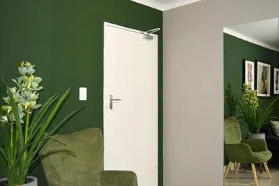 a white door in a room with green walls at Moon Octave in Midrand