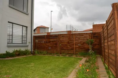 a backyard with a wooden fence and a yard at Moon Octave in Midrand