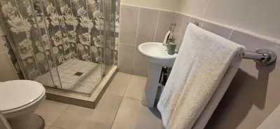 a bathroom with a toilet and a sink and a shower at Ekuhlaleni - A home away from home R8 in Pretoria
