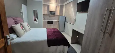a small room with a bed and a kitchen at Ekuhlaleni - A home away from home R8 in Pretoria