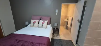 a bedroom with a bed with pink and white pillows at Ekuhlaleni - A home away from home R8 in Pretoria