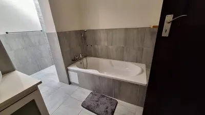 a bathroom with a bath tub and a shower at 21 on Main in Benoni