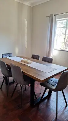 a large wooden table in a room with chairs at 21 on Main in Benoni
