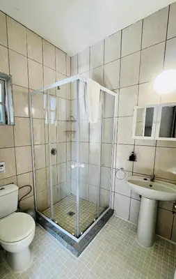 a bathroom with a shower and a toilet and a sink at Follyfoot Manor in Midrand