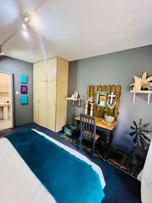 a bedroom with a bed and a desk and a table at Follyfoot Manor in Midrand