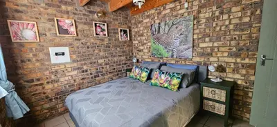 a brick wall with a bed in a room at Cottage On Naboom in Marloth Park