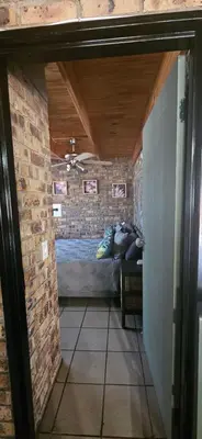 a bedroom with a bed in a brick wall at Cottage On Naboom in Marloth Park