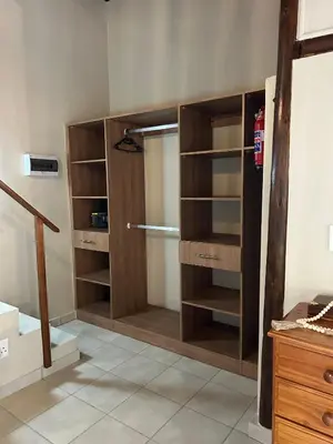 a closet with wooden shelves in a room at The Thatched Cottage in Benoni