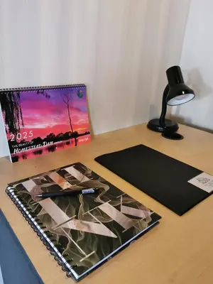 a desk with a laptop and a picture on it at The Thatched Cottage in Benoni