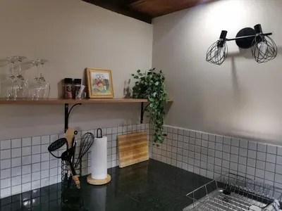 a kitchen with a sink and a shelf with utensils at The Thatched Cottage in Benoni