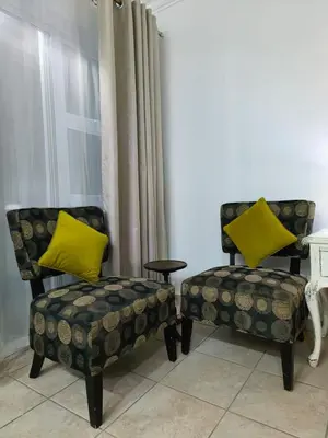 two chairs with yellow pillows sitting next to a window at Wag-n-Bietjie in Centurion