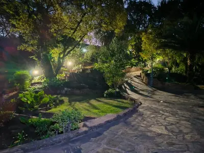 a garden at night with trees and a stone path at Wag-n-Bietjie in Centurion