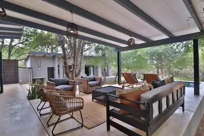 a patio with couches and a table and chairs at Maroela Skadu in Marloth Park in Marloth Park