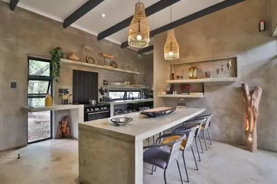 a large kitchen with a large island with chairs at Maroela Skadu in Marloth Park in Marloth Park