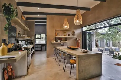 a large kitchen with a large island with chairs at Maroela Skadu in Marloth Park in Marloth Park
