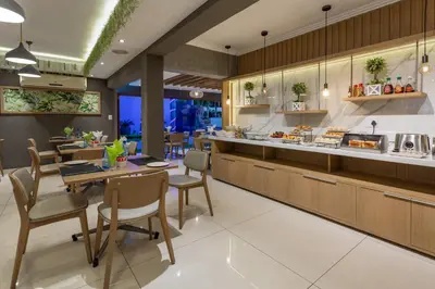 a kitchen with tables and chairs and a counter at The Cycad Lodge & Chalets in Nelspruit