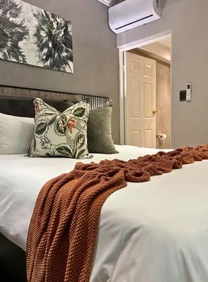 a bedroom with a bed with a blanket on it at The Cycad Lodge & Chalets in Nelspruit