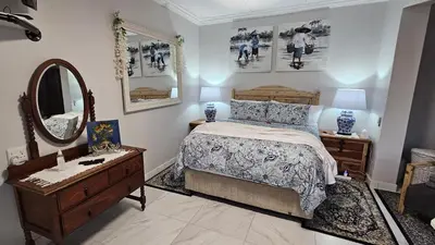 a bedroom with a bed and a dresser and a mirror at Upstairs R-4 Self Catering Unit in White River