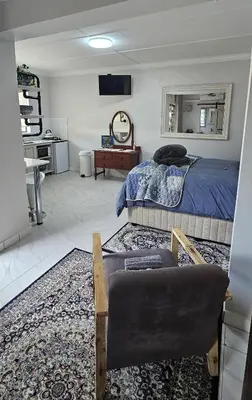 a bedroom with a bed and a couch and a chair at Upstairs R-4 Self Catering Unit in White River