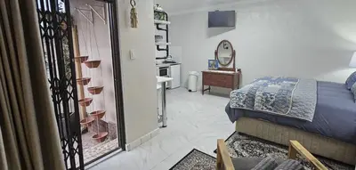 a bedroom with a bed and a bathroom with a mirror at Upstairs R-4 Self Catering Unit in White River