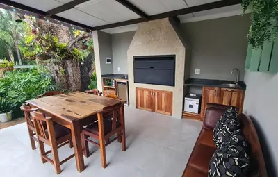 a living room with a wooden table and a television at Upstairs R-4 Self Catering Unit in White River
