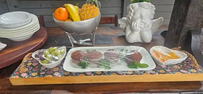 a table with a plate of food and a bowl of fruit at Rose Stable Cottage in Pretoria