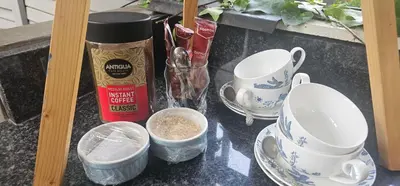 a table with cups and dishes on a counter at Rose Stable Cottage in Pretoria