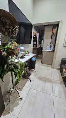 a living room with a table and a kitchen at Rose Stable Cottage in Pretoria